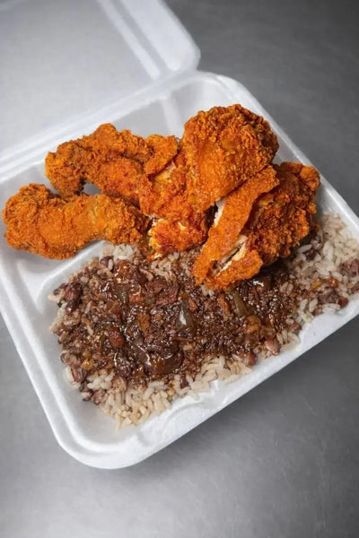Fried chicken and rice in a takeout container on a gray surface - Jerk Fry City